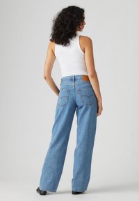 Hooggesneden, wijde denim jeans in middelblauw, met een leren achterkant, twee achterzakken en een casual pasvorm.