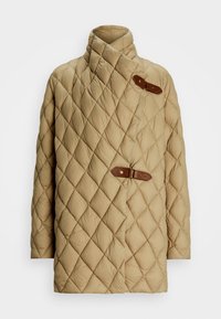 Casaco bege acolchoado com gola alta e costura diagonal; apresenta dois fechos em fivela de couro. Textura macia e fofa.