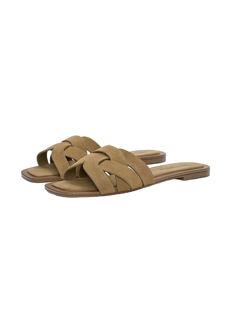 Brown suede slide sandals with crisscross strap design and a flat sole. Soft texture and minimalistic shape. Suitable for casual wear.