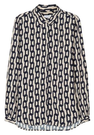 Blusa de manga larga color crema con patrón de eslabones negros, cierre frontal con botones y cuello puntiagudo.