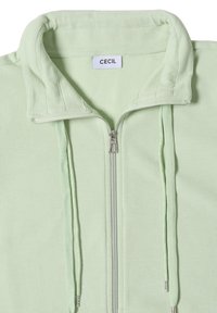 Light green zip-up sweatshirt with high collar and matching drawstrings, featuring a CECIL brand label inside the neck.