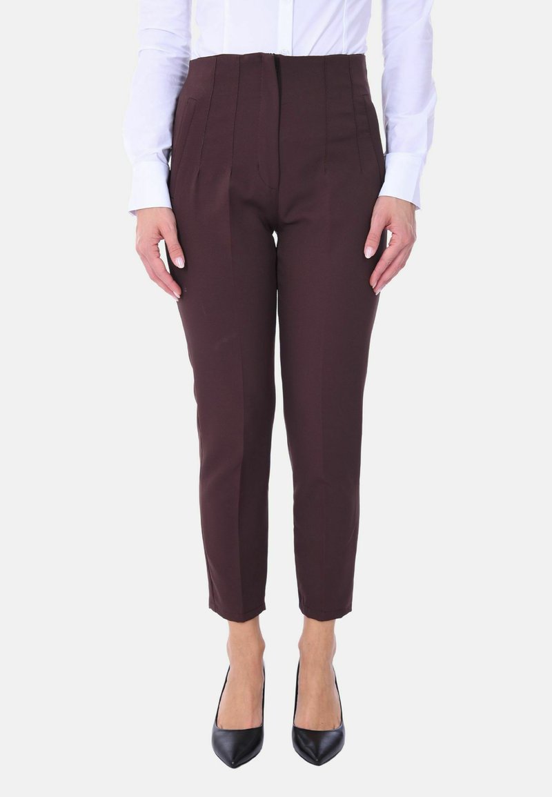 Pantaloni in borgogna su misura con pieghe, lunghezza cropped, texture liscia, abbinati a una camicia bianca aderente e tacchi neri appuntiti.
