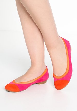 Ballerines en daim rose et orange avec un bout rond, une semelle plate et des accents contrastés. Tige texturée avec des détails de coutures visibles.