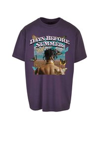 Lilla bomulds t-shirt med et grafikprint med teksten "DAYS BEFORE SUMMER" og farverige sommerfugle omkring en persons ryg.