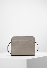 Szara torebka na ramię o fakturze krokodyla, prostokątnym kształcie i regulowanym pasku, umieszczona na białym piedestale na prostym tle.