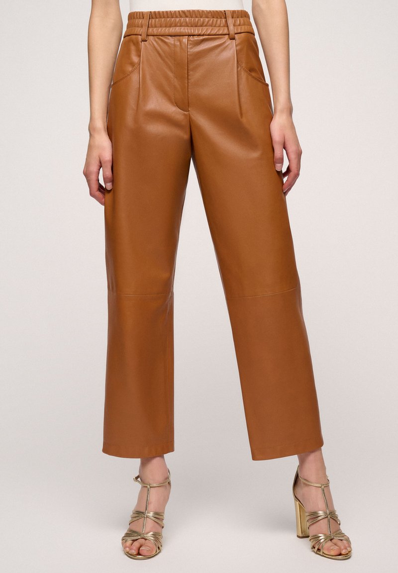 Brown faux leather pants with an elastic waistband, wide-leg design, and side pockets, featuring a smooth texture and clean lines.