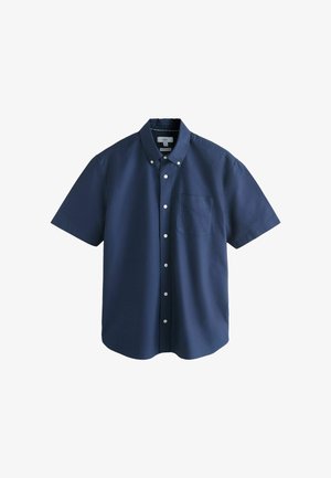 Tumši zila īsroku pogājama krekls ar pogājamu apkakli un krūšu kabatu, attēlots plakani uz balta fona.