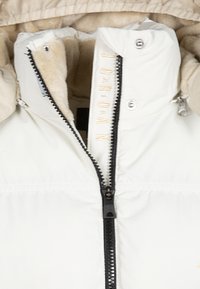 White puffer jacket with a beige faux fur lining, featuring a black zipper and gold embroidered lettering on the collar.