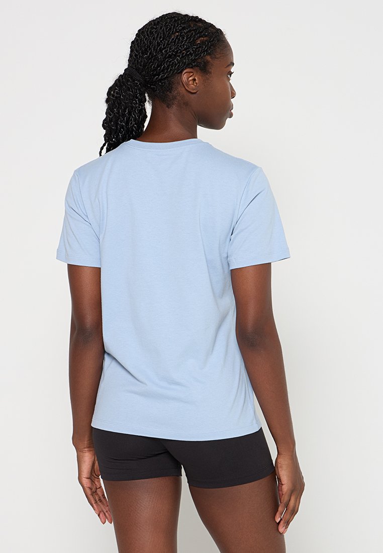 Helles blaues Baumwoll-T-Shirt mit kurzen Ärmeln, rundem Hals und lockerer Passform. Wird mit schwarzen Shorts getragen, von hinten gezeigt.