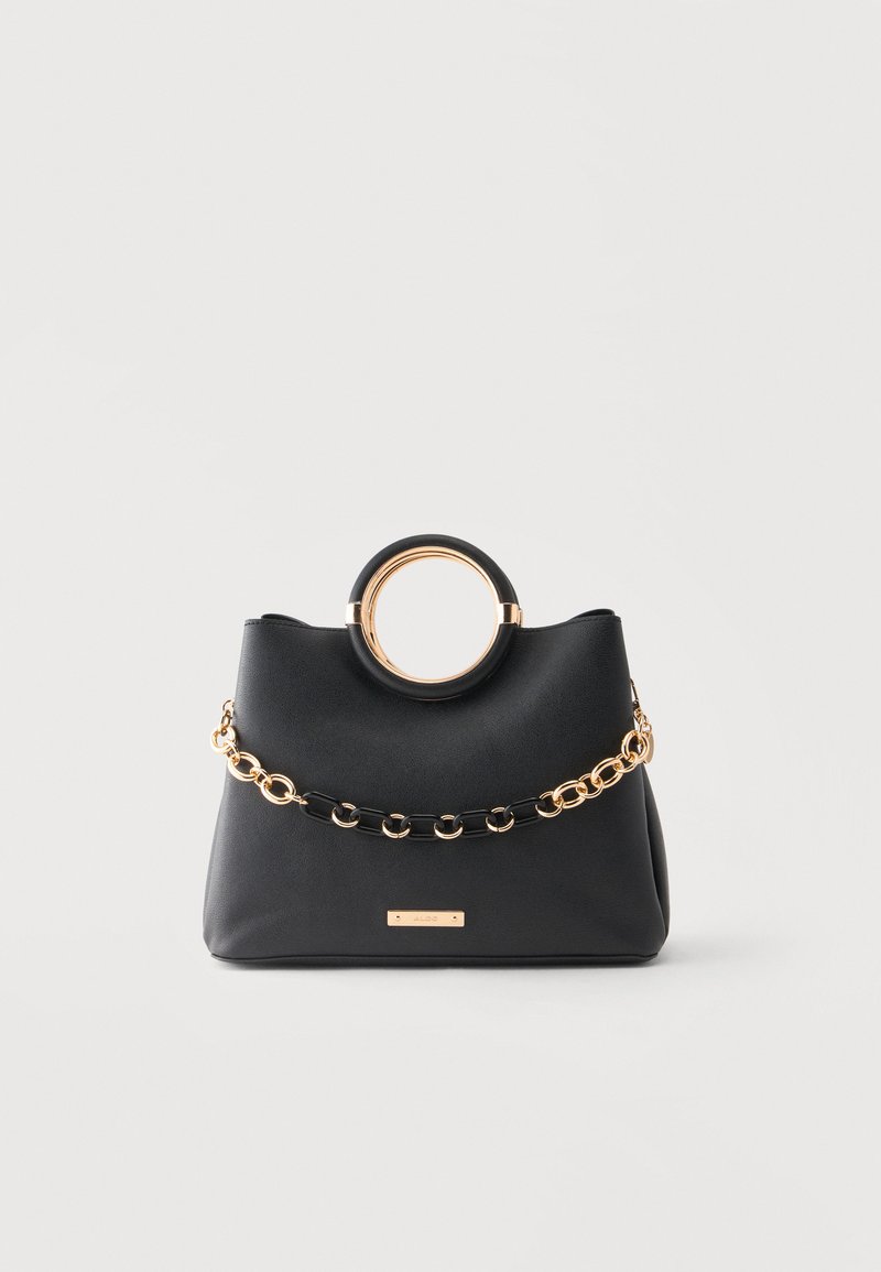 Sac à main noir avec des poignées rondes ornées d’accent doré et une chaîne décorative dorée et noire sur le devant, sur un fond clair uni.