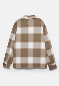 Brun och vit rutig flanellskjorta med krage, som har långa ärmar, knappade manschetter och en mjuk textur.