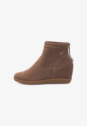 Brązowe zamszowe botki za kostkę na koturnie, z bocznym zamkiem błyskawicznym i przeszywanym wzorem. Dyskretny logo wytłoczone po zewnętrznej stronie.