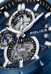 Mėlynas ir sidabrinis policijos laikrodis, turintis kelis ciferblatus, tekstūruotą foną, modernius rodykles, datos indikatorius ir išsiskiriantį prekės ženklo logotipą.