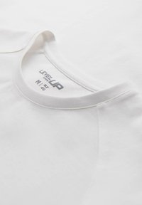 Hvid bomulds T-shirt med rund halsudskæring. Har et trykt mærke med teksten "LEVELUP M 48" i grå. Blød tekstur og enkelt design.
