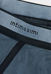 Ciemnoniebieskie bokserki z teksturowanym pasem w czarnych akcentach oraz nazwą marki "intimissimi" w eleganckiej czcionce.