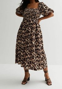 Leopardenmuster Midi-Kleid mit quadratischem Ausschnitt, gerafftem Oberteil, Puffärmeln und fließendem Saum. Kombiniert mit schwarzen Riemchen-High-Heels.