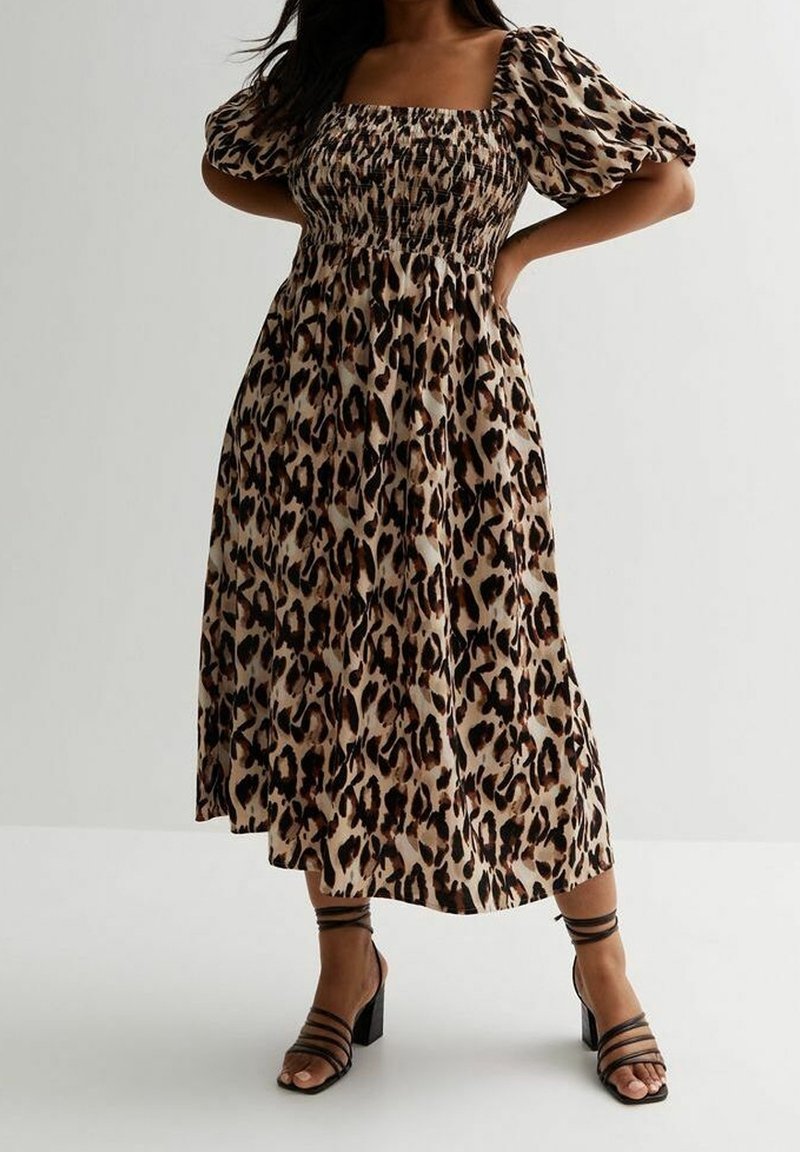 Leopardenmuster Midi-Kleid mit quadratischem Ausschnitt, gerafftem Oberteil, Puffärmeln und fließendem Saum. Kombiniert mit schwarzen Riemchen-High-Heels.