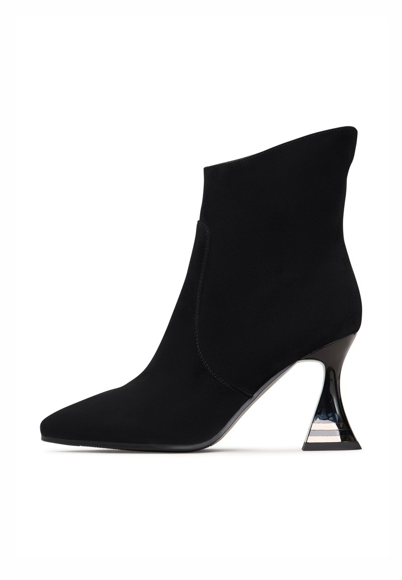 Crni gležnjači napravljeni od glatke tkanine, s oštrim vrhom i prepoznatljivim trokutastim potpeticama s metalnim naglaskom.