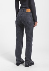 Jeans in denim nero con un design a gamba dritta, dotati di un'etichetta in pelle sulla cintura posteriore e due tasche posteriori.