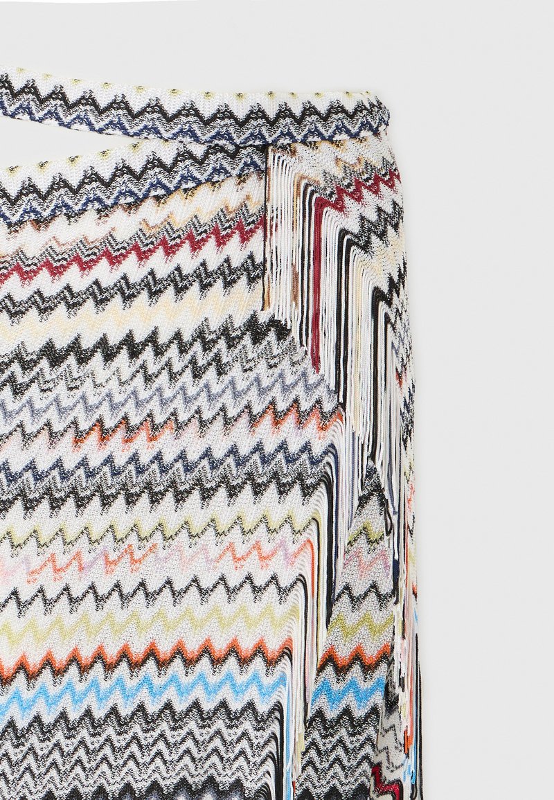 Jupe en tricot avec motif zigzag multicolore en noir, blanc, rouge, bleu, orange et jaune, dotée d'une ceinture et d'une fermeture éclair latérale.