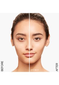 Porównanie przed i po na twarzy; lewa strona pokazuje niedoskonałości, prawa strona gładką skórę. Etykiety tekstowe "PRZED" i "PO 210 Birch."