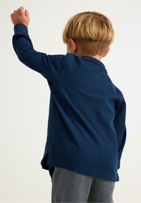 Navy blue long-sleeve polo shirt with a textured fabric and a classic collar, featuring side slits for ease of movement.
