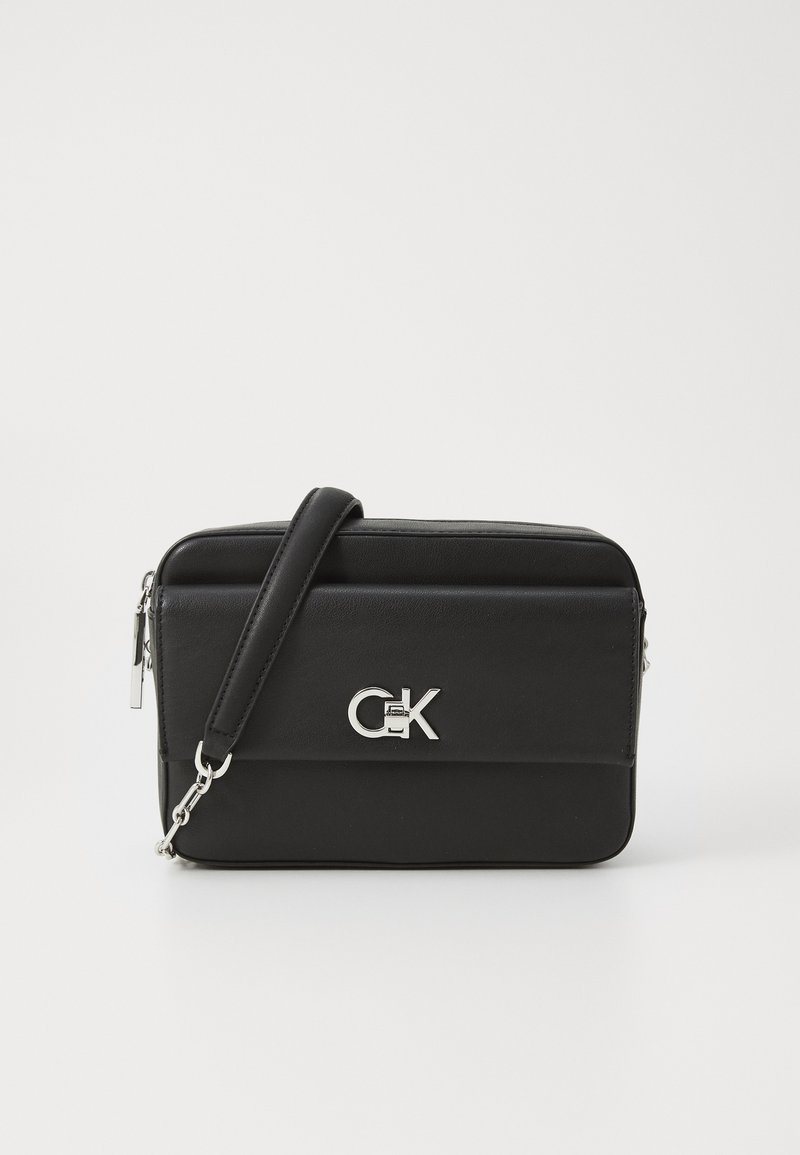 Borsa a tracolla in pelle nera con hardware argentato, dotata di logo frontale, chiusura con zip e tracolla regolabile. Forma rettangolare, texture liscia.