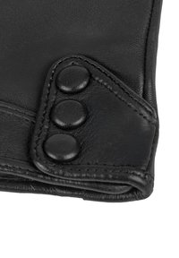 Puño de guante de cuero negro con tres botones a presión negros cosidos y detalle de costura visible.