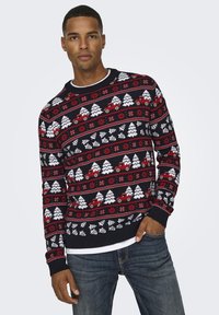 Maglione lavorato a maglia con motivi rossi, bianchi e neri di alberi, fiocchi di neve e camion. Polsini e orlo a coste, design a girocollo.