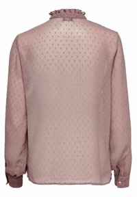 Long-sleeve blouse in soft pink, featuring textured polka dot patterns and a ruffled neckline, with buttoned cuffs and a slightly loose fit.