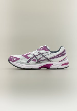 Chaussure de course athlétique blanche et violette avec des accents noirs, tige en mesh, lacets et semelle amortie sur fond neutre.