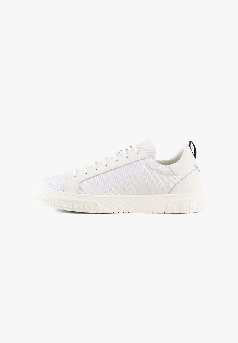 Baskets blanches avec un dessus en cuir lisse et en mesh, bout rond et semelle en caoutchouc texturé. Comprend une languette noire à l'arrière.