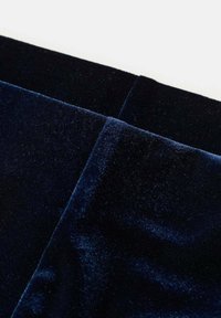 Taflă de catifea de culoare albastru marin, textură moale, ușoară strălucire, două secțiuni care se suprapun cu cusături vizibile, adâncime bogată a culorii și suprafață netedă.