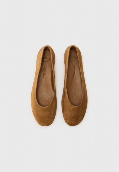 Bailarinas de ante marrón con puntera redondeada y interior de cuero suave. Diseño minimalista, sin herrajes ni acentos adicionales.