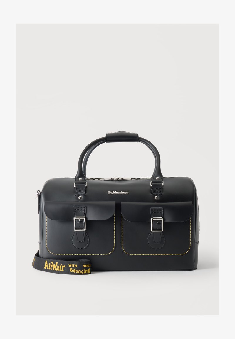 Μαύρη δερμάτινη τσάντα Dr. Martens με δύο μπροστινές τσέπες με αγκράφες, διπλές χειρολαβές και αποσπώμενο λουράκι με κίτρινο λογότυπο AirWair.
