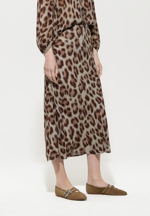 Braun und beige Leopardenmuster-Kleid mit einem Bindedetail am Ausschnitt, kombiniert mit hellbraunen Ballerinas mit dekorativen Schnallen.