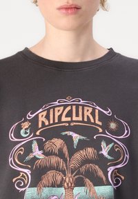 Dark gray sweatshirt with a round neckline featuring a colorful graphic design of a palm tree, birds, and the text "RIPCURL."