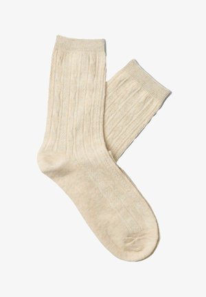 Beżowe prążkowane skarpetki dziane z fakturowanym wzorem i elastycznymi mankietami. Miękki, lekki materiał zaprojektowany dla komfortu i ciepła.