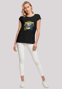 Schwarzes Baumwoll-T-Shirt mit einem bunten Grafikdruck von David Bowie und dem Text "Live in Concert 1973". Kurze Ärmel, lockere Passform.