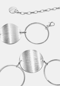 Collana con catena d'argento con due ciondoli circolari lucidi con texture spazzolata e chiusura con fibbia.