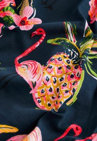 Bomullstyg med en mörk marinblå bakgrund, prytt med ljusa rosa flamingos, gula ananaser och färgstarka tropiska blommor.