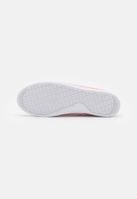 Niedriger Sneaker mit einer weißen Gummisohle, strukturiertem Grip-Muster und pinkem Canvas-Obermaterial. Verfügt über Branding an der Seite und Ferse.