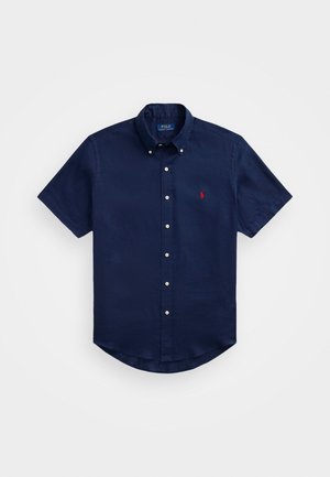 Marineblå kortermet skjorte med knapper i lett stoff og avslappet passform. Har en rød logo på brystet og en klassisk kragedesign.