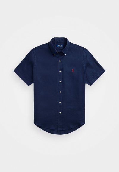 Ναυτικό κοντομάνικο πουκάμισο με κουμπιά από ελαφρύ ύφασμα και χαλαρή εφαρμογή. Διαθέτει κόκκινο λογότυπο στο στήθος και κλασικό σχέδιο γιακά.