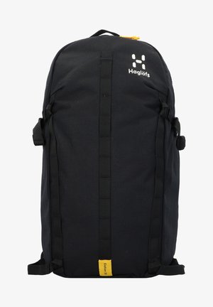 Schwarzer Rucksack aus strapazierfähigem Material, mit vertikalen Schultergurten, einem gelben Akzent am Boden und einem auffälligen weißen Logo oben.
