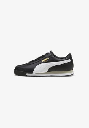 Black leather sneaker with white accents, lace-up design, gold logo detail, and a durable rubber sole, featuring a classic athletic shape.