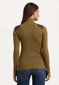 Pull à col roulé côtelé en vert olive avec des accents en cuir marron sur les épaules. Manches longues et coupe ajustée, fabriqué en tissu tricoté texturé.