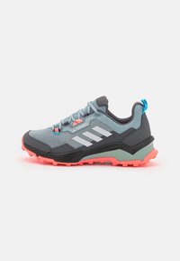 Zapato de senderismo para hombre con parte superior de malla en azul claro y gris, con acentos naranjas, franjas blancas y una suela rosa rugged para tracción.