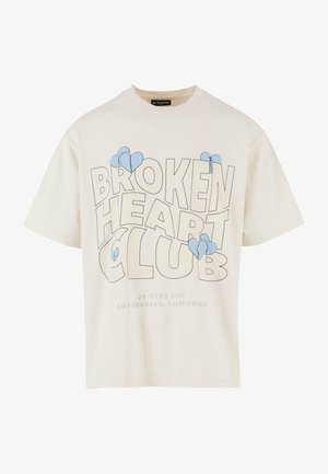 Crèmekleurig katoenen T-shirt met een ronde hals, voorzien van vetgedrukte zwarte tekst "BROKEN HEART CLUB" en blauwe hartgraficen aan de voorkant.