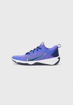 Nike Sportschuhe in Lila und Marineblau. Sie verfügen über ein strukturiertes Mesh-Obermaterial, einen kontrastierenden blauen Swoosh mit Punkten und eine weiße Zwischensohle.